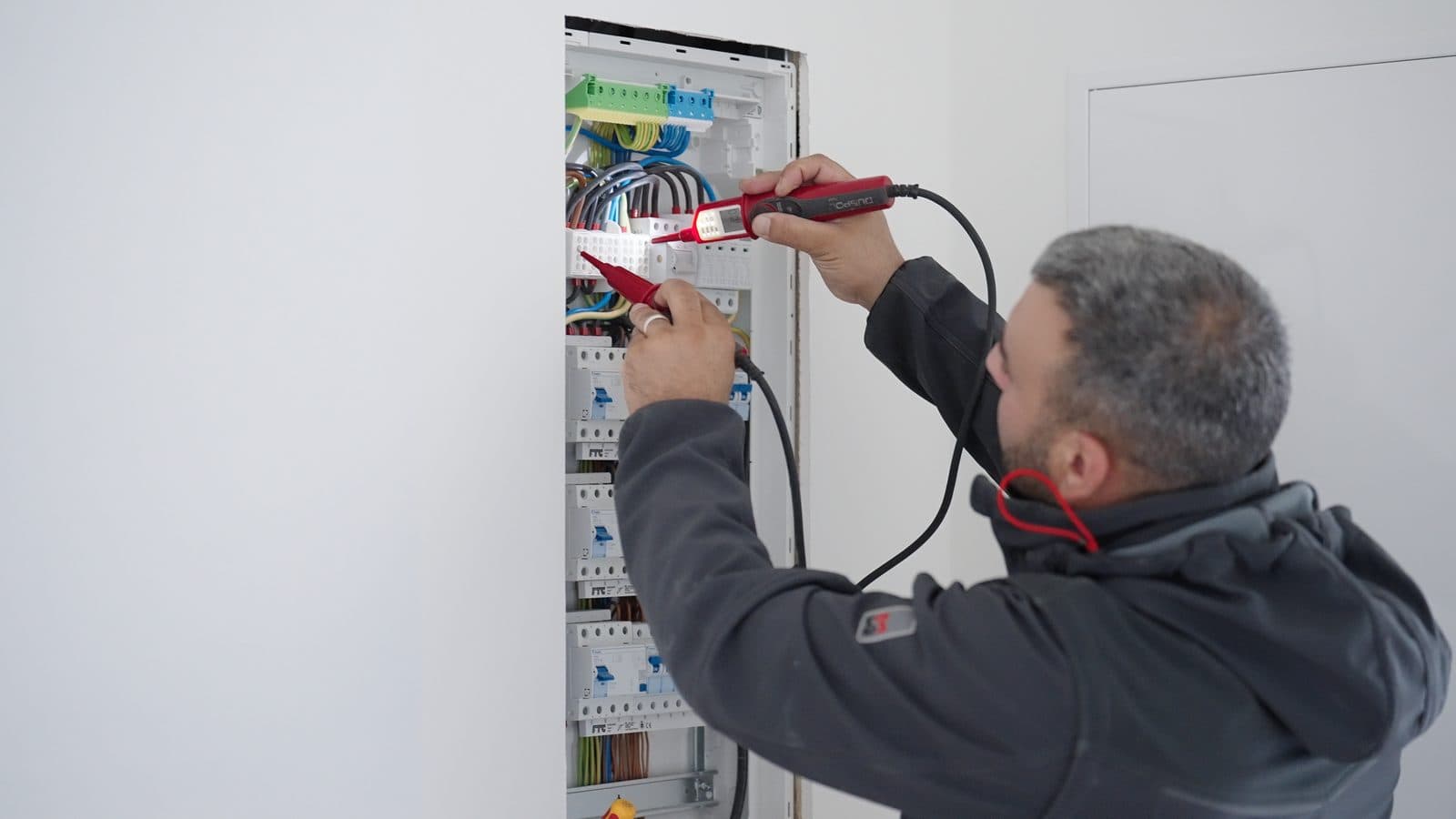Elektriker der Alfa Projektbau am Verteilerschrank
