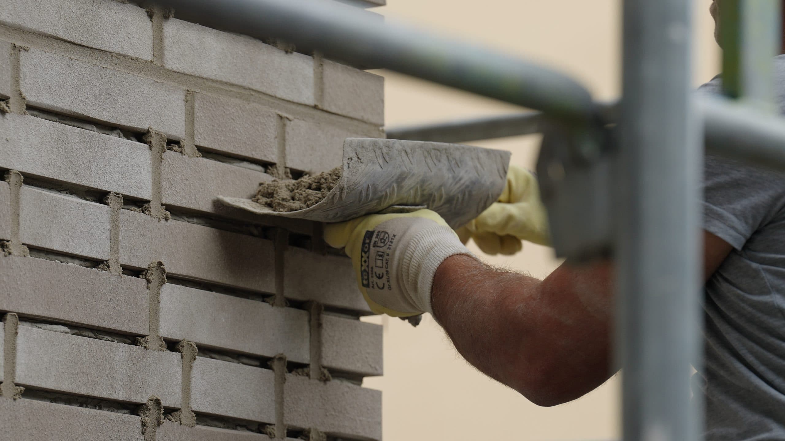 Close-up: trowel with mortar while laying the clinker facing brickwork